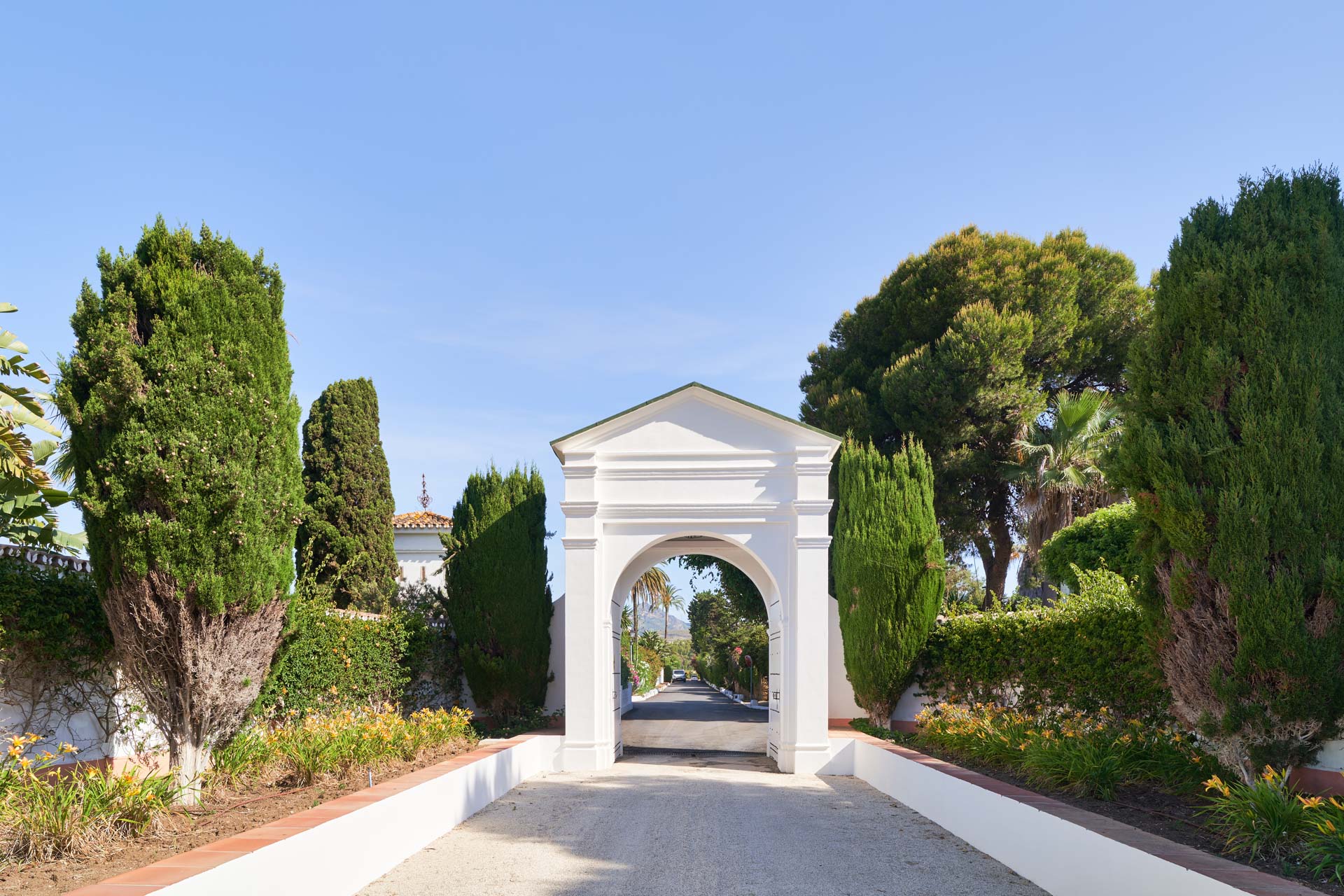 Fotografía de la entrada en arco, puerta en color blanco para acceder al alojamiento